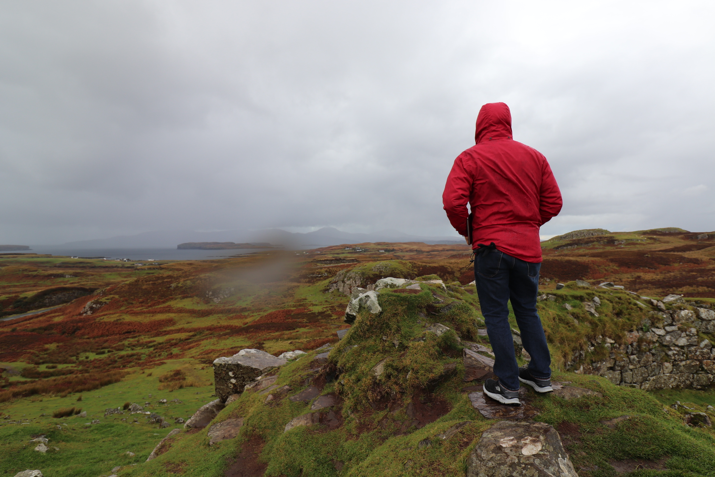 man standing on hill overlooking ocean