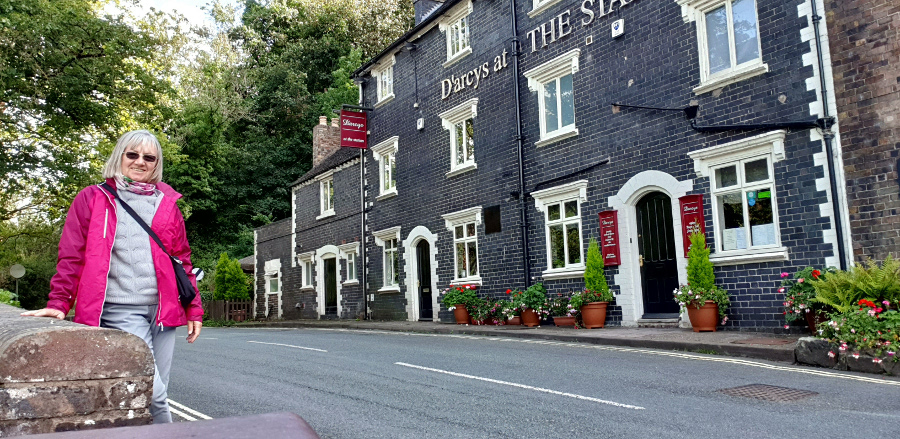 Woman smiling at the camera next to english pub