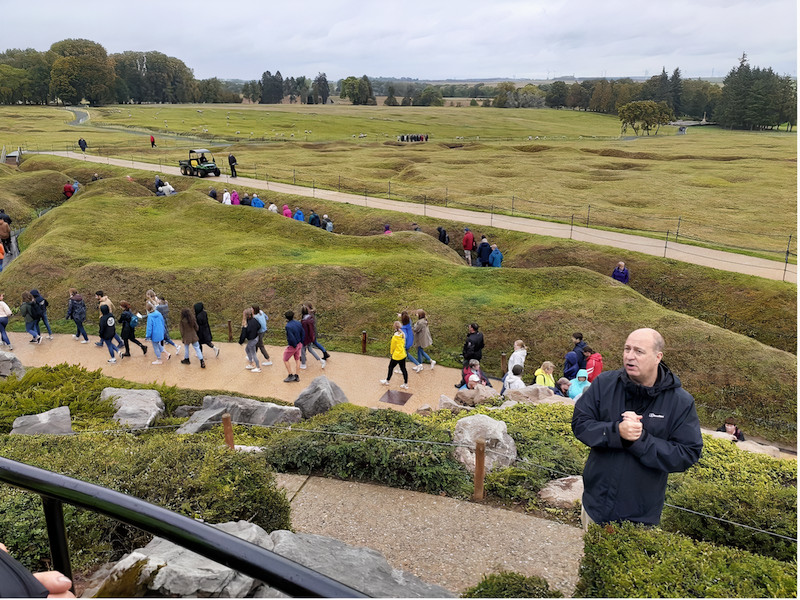 battlefield of Beaumont-Hamel Newfoundland Memorial with people walking past the trenches and Tour Leader Steve in the foreground