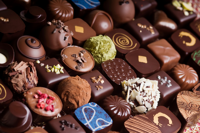 close up showing rows of milk and dark Swiss chocolates with decorative toppings