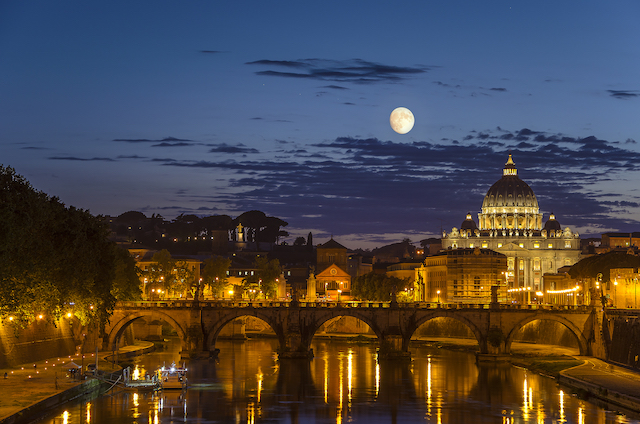 night view of Rome showing St. Peter's Basilica under a full moon