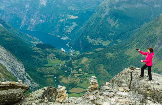 A Blueroads traveler looks out over a Fjord from Europe's highest Fjord Viewpoint at Dalsnibba Summit. 