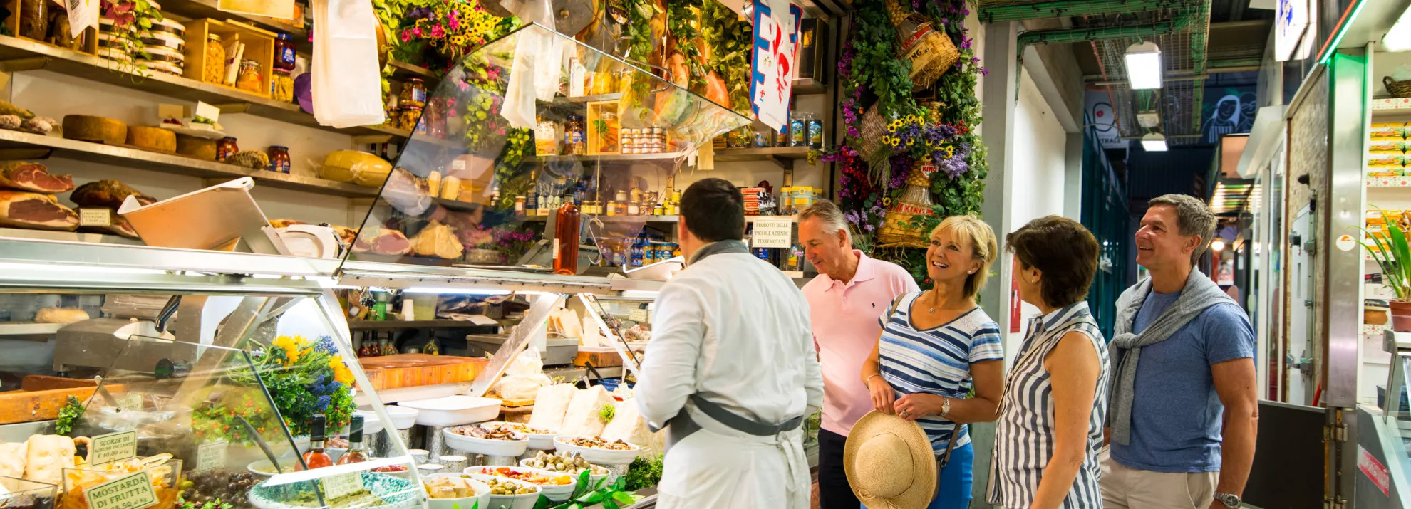 group of mature travellers conversing at a European market stall