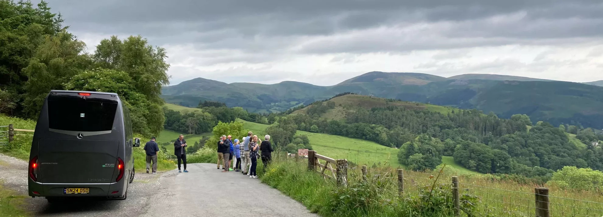 a tour group outside of the coach enjoying the view