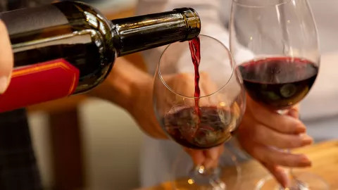 Glasses of wine being poured at a wine tasting event.