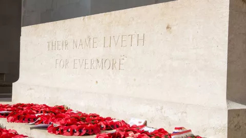 A view of one of the memorial graves at Thiepval, rings of poppies decorating the base.