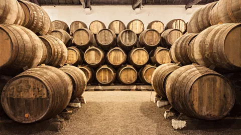 Rows of different whiskey line the walls of a distillery.