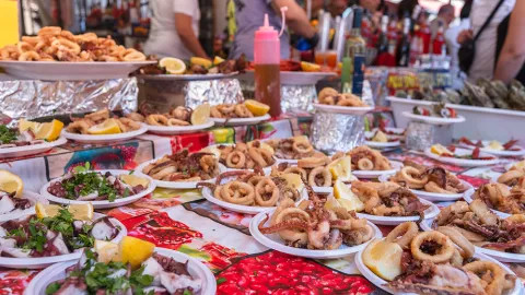 Plates of Italian street food at a market stall.