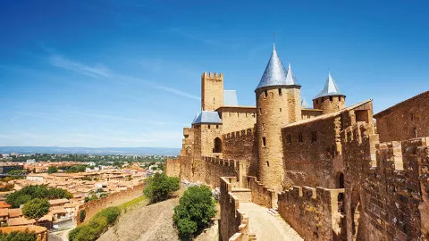 The iconic fortress of Carcassone looms over the city on a sunny day.