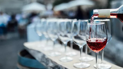 A server pours a glass of wine in preparation for a wine tasting experience.