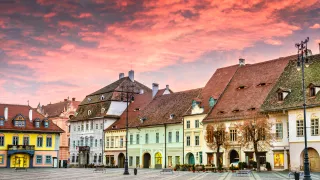 A view of the Large Square in the town of Sibiu during dusk.