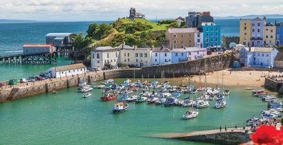 A view of the small port town of Tenby, with a collection of boats by the pier.