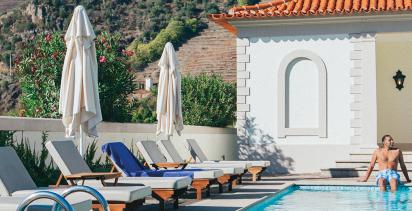 A traveler resting on the edge of a pool at a hotel.