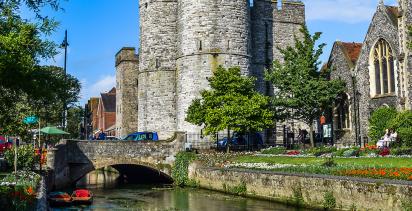 A view of a feudal castle by a canal in the city of Canterbury.