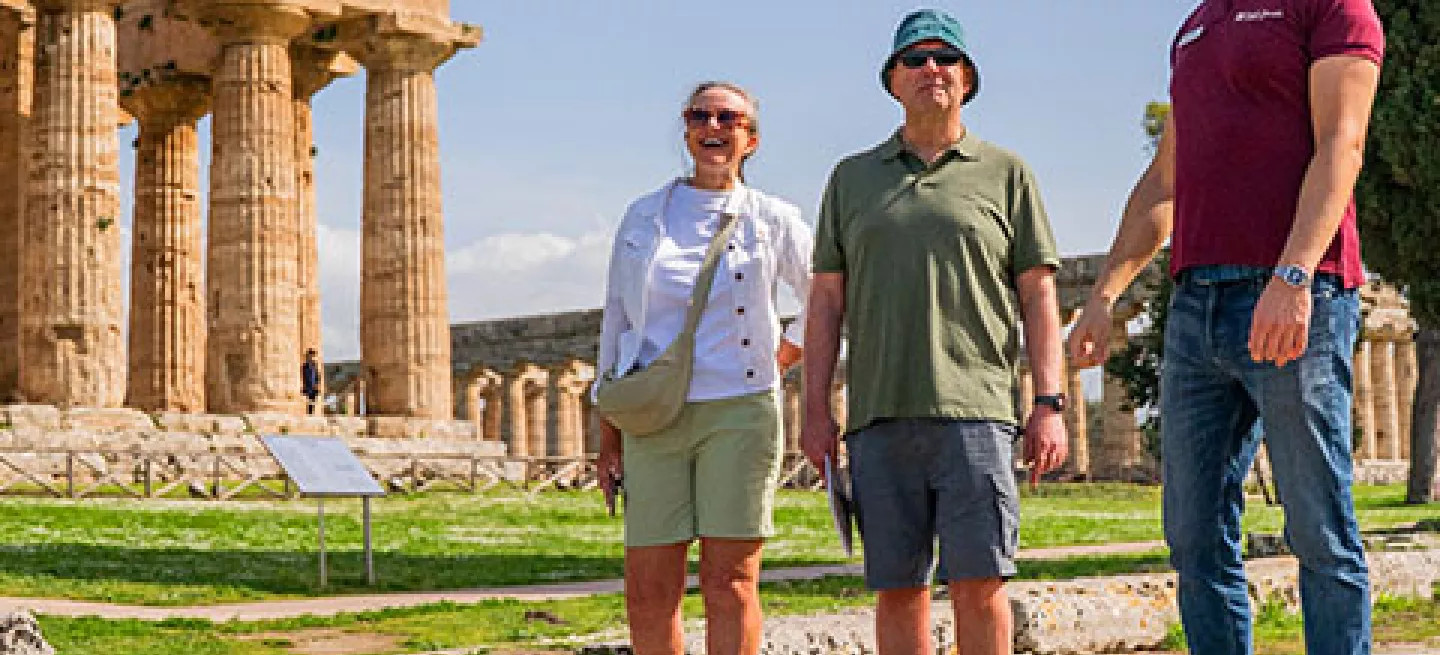 Tour leader guides a small-group around Paestum archeological site in Italy.