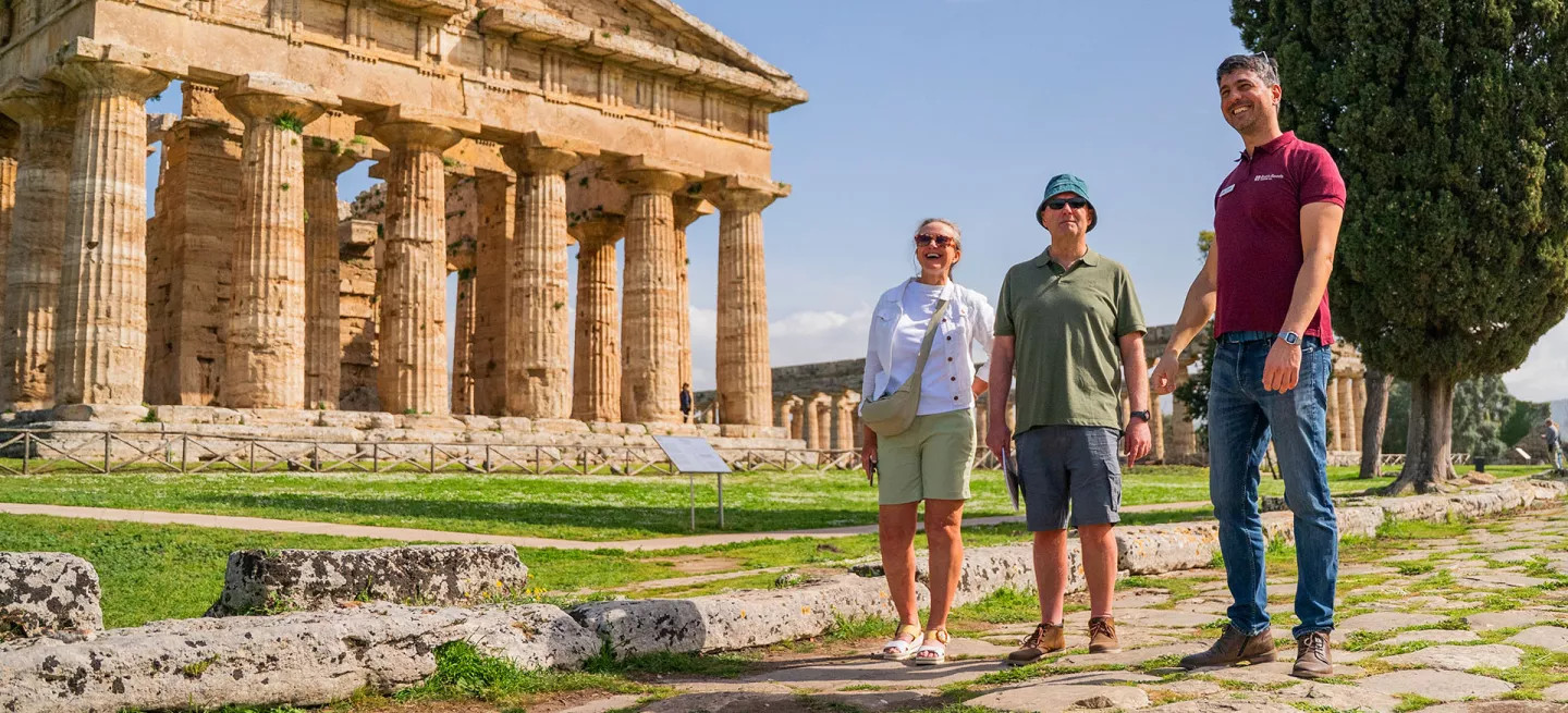 Tour leader guides a small-group around Paestum archeological site in Italy.