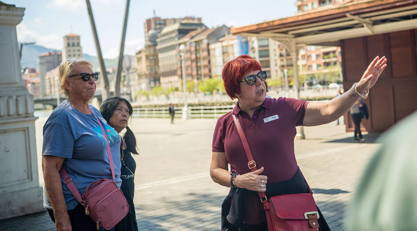 A Blue-Roads tour leader speaking to two guests